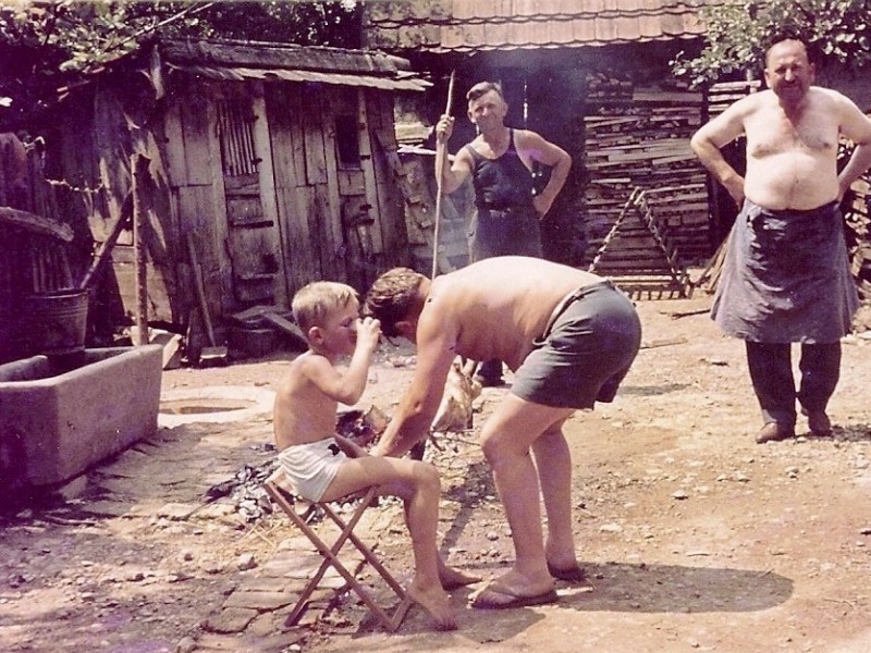  Pečenje janjeta na dan Velike gospe na sred dvorišta kako bi to mogli vidjeti svi prolaznici. No, ova fotografija ne prikazuje pečenjare iz Prekopakre, već iz Filipovca, iako kod njih nije proštenje za Gospu već za Spasovo (svetkovina Uzašašća Gospodinova),  Snimljeno u dvorištu Stjepana Šergera 1963. godine. Na slici naprijed: Tomislav (sjedi) i Josip Mrazović iz Bjelovara,  desno Marko Čačić iz Osijeka i domaćin Stjepan Šerger.   Sliku ustupio Damir Palatinuš iz Daruvara.