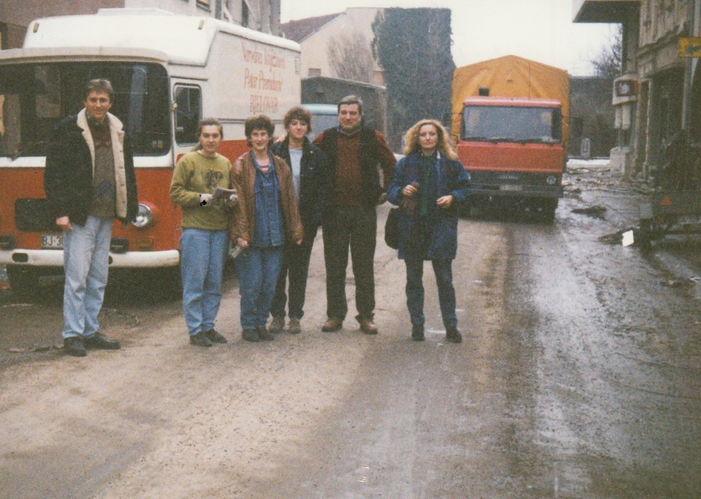 Fotografija: Djelatnici Narodne knjižnice Petar Preradović Bjelovar ispred teško postradale Knjižnice u Pakracu – 29. siječanj 1992. g.  Slijeva: Marinko Iličić, Danijela Pranjić, Zorka Renić, Snježana Berak, Željko Prohaska i Ljiljana Orlić 